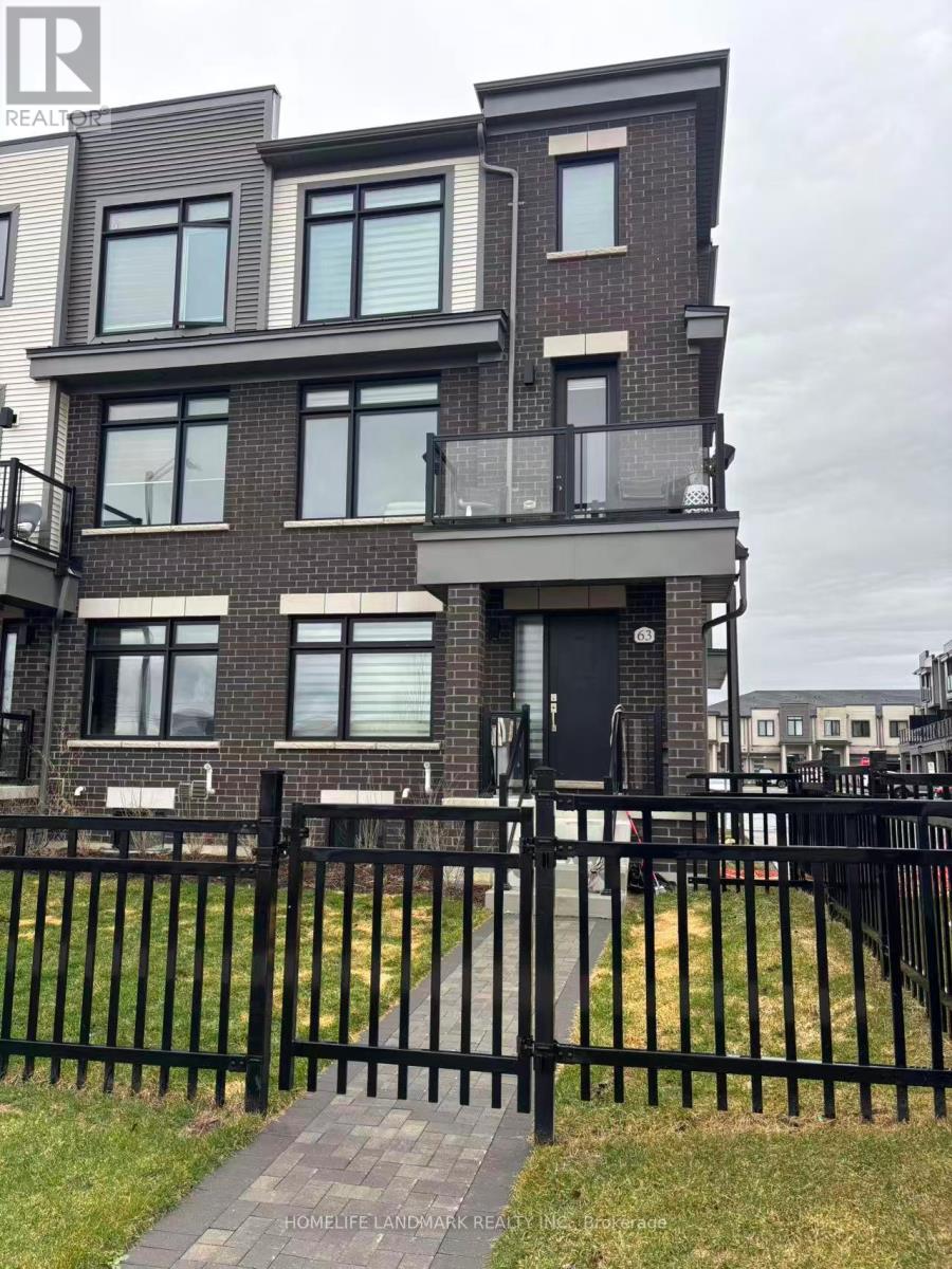 A modern brick house with a black fence in front.