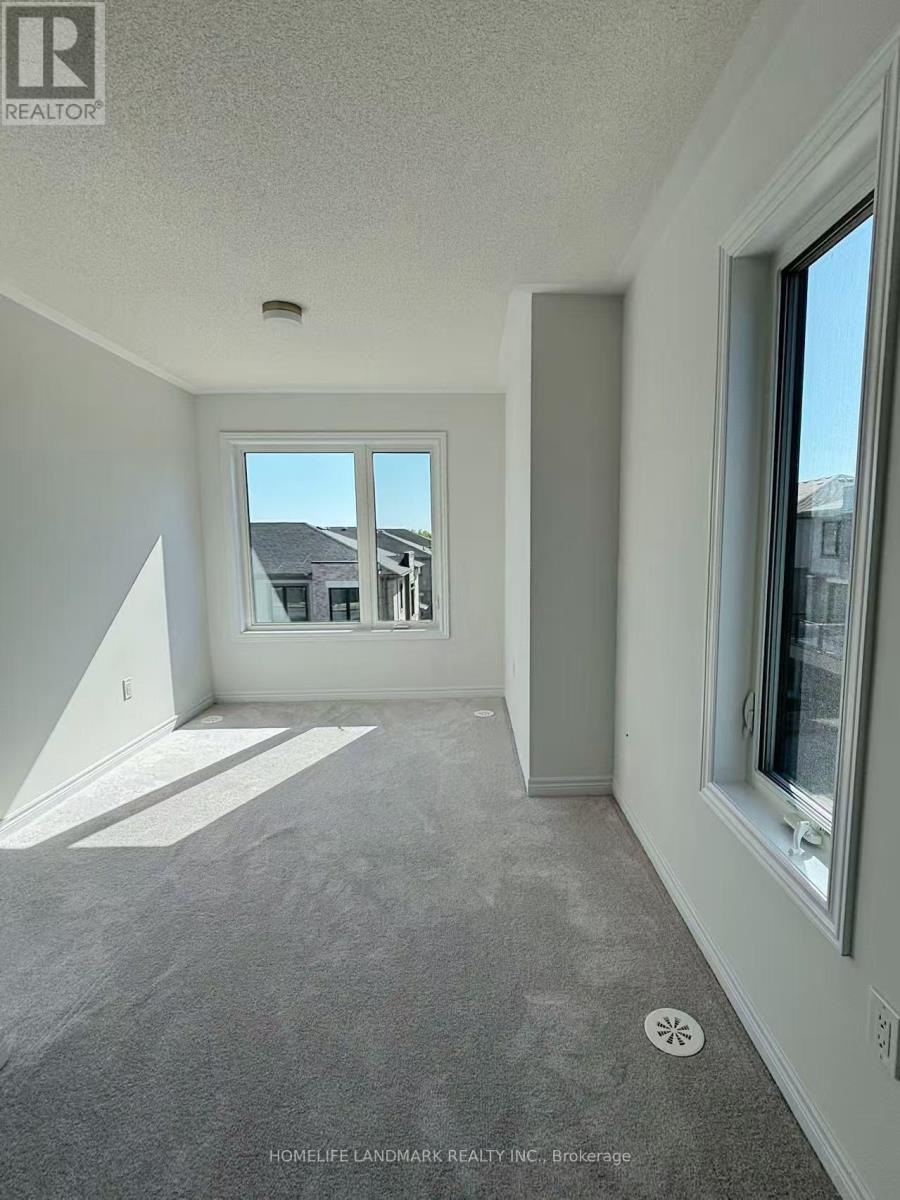 A room with a carpet floor and a window overlooking a building.