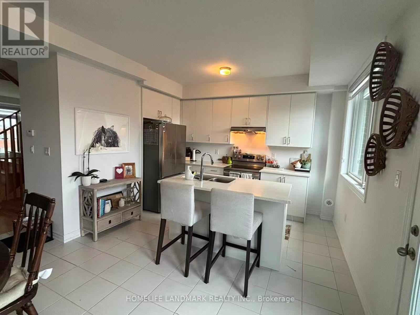 A kitchen with white cabinets and a white table.