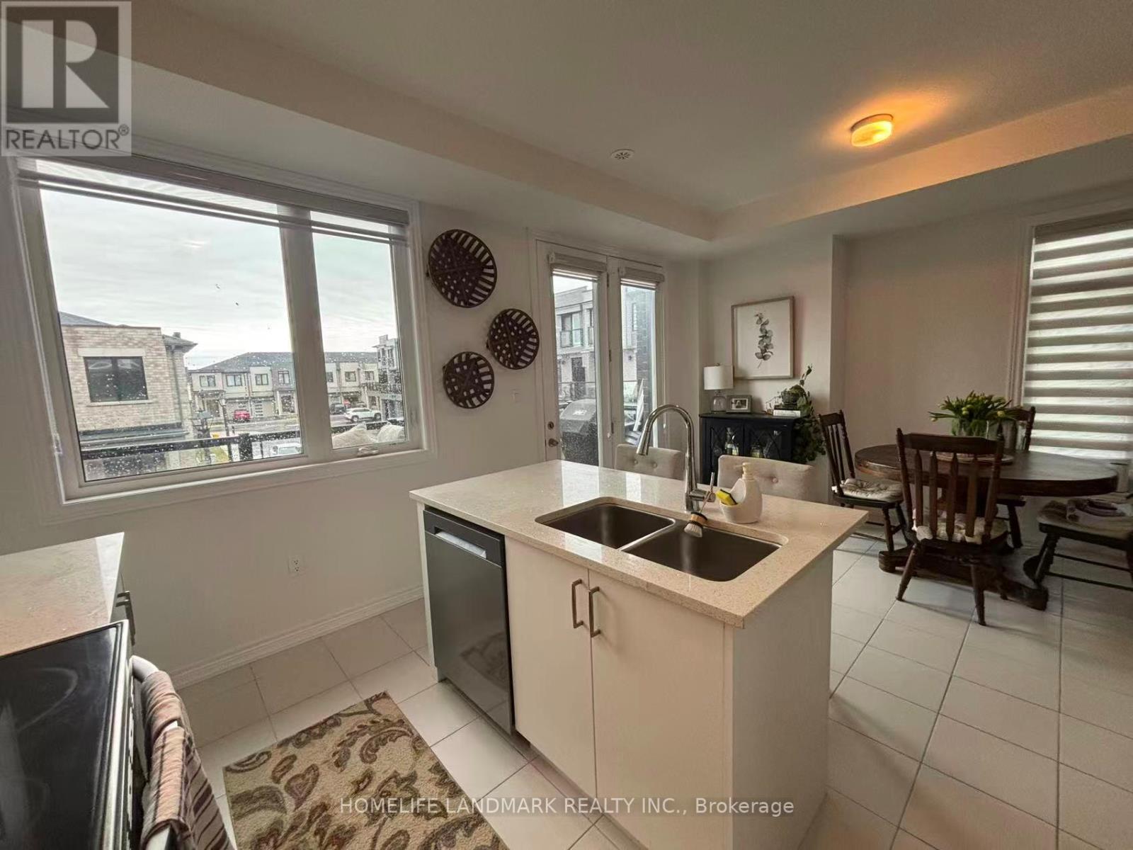 A kitchen with white cabinets and a black dishwasher.