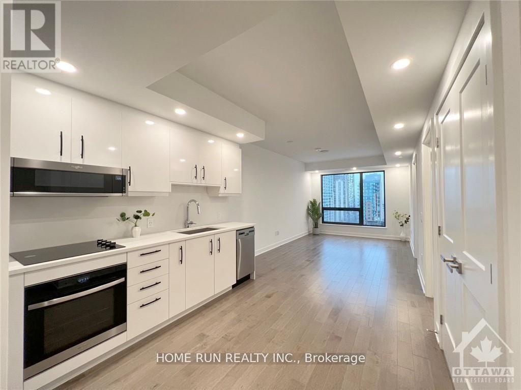 A modern kitchen with white cabinets and stainless steel appliances.
