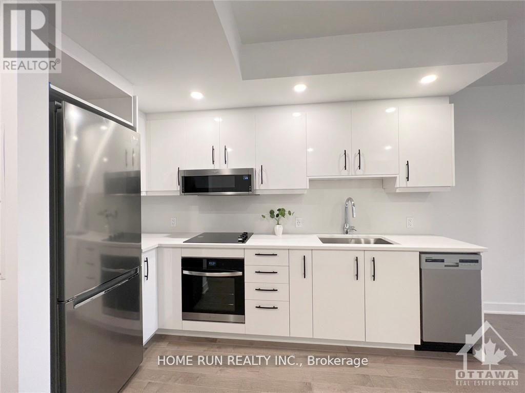A modern kitchen with white cabinets and stainless steel appliances.