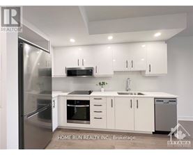 A modern kitchen with white cabinets and stainless steel appliances.