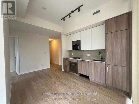 A modern kitchen with wooden cabinets and a microwave above the stove.