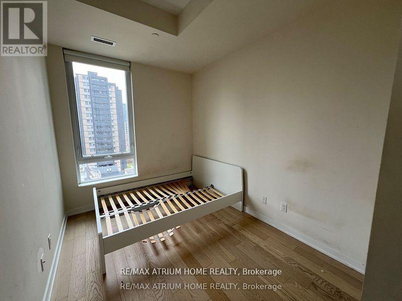 A bedroom with a bed and a window overlooking a city.