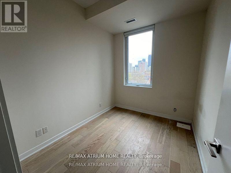 A room with a window and wooden flooring is for sale.