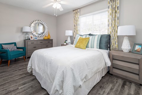 A bedroom with a large bed and a blue chair.