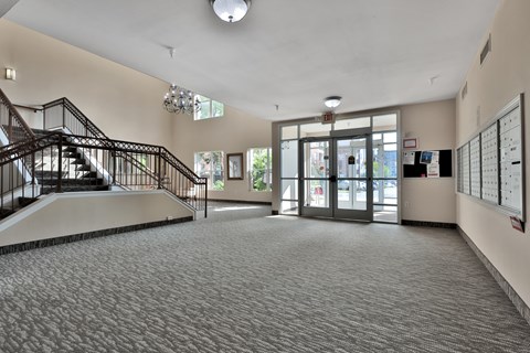 A spacious foyer with a staircase and a chandelier.