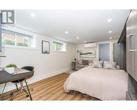 A bedroom with a bed, desk, and chair.