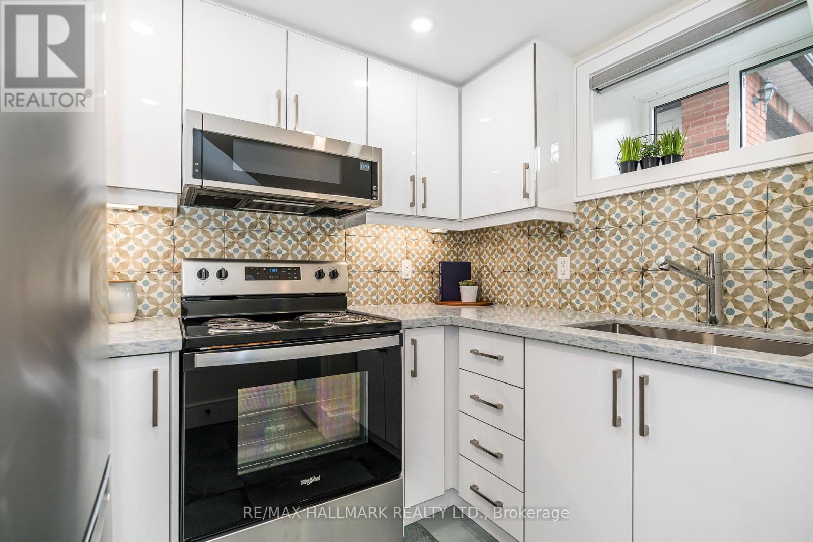 A kitchen with white cabinets and a black oven.