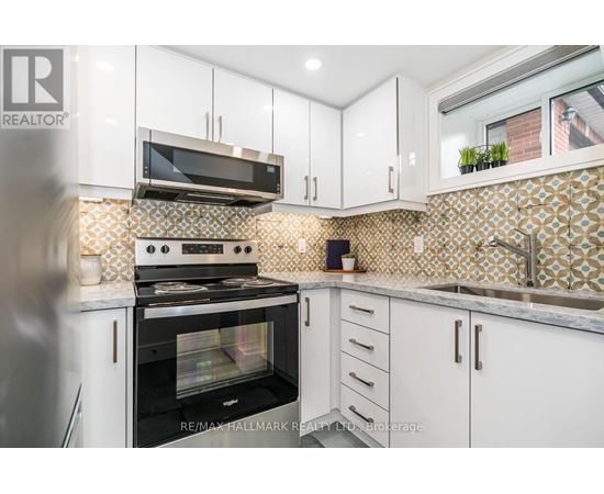 A kitchen with white cabinets and a black oven.