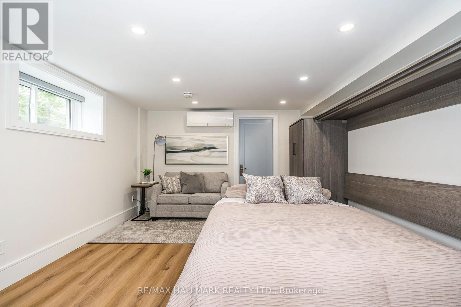 A bedroom with a large bed and a couch in the background.