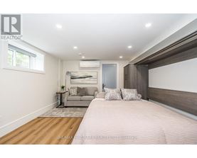 A bedroom with a large bed and a couch in the background.