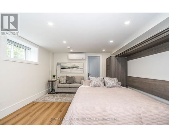 A bedroom with a large bed and a couch in the background.
