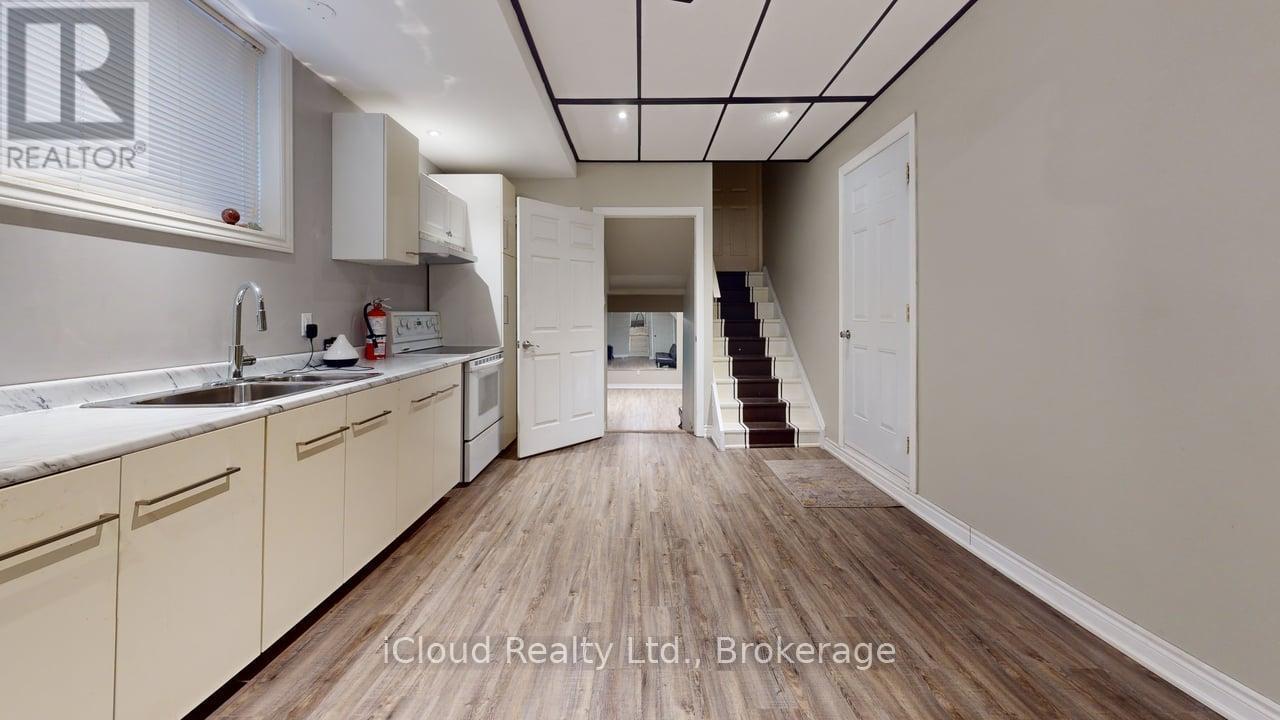A kitchen with wooden floors and white cabinets.