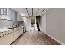 A kitchen with wooden floors and white cabinets.