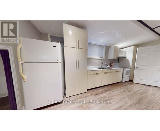 A kitchen with a refrigerator and cabinets.