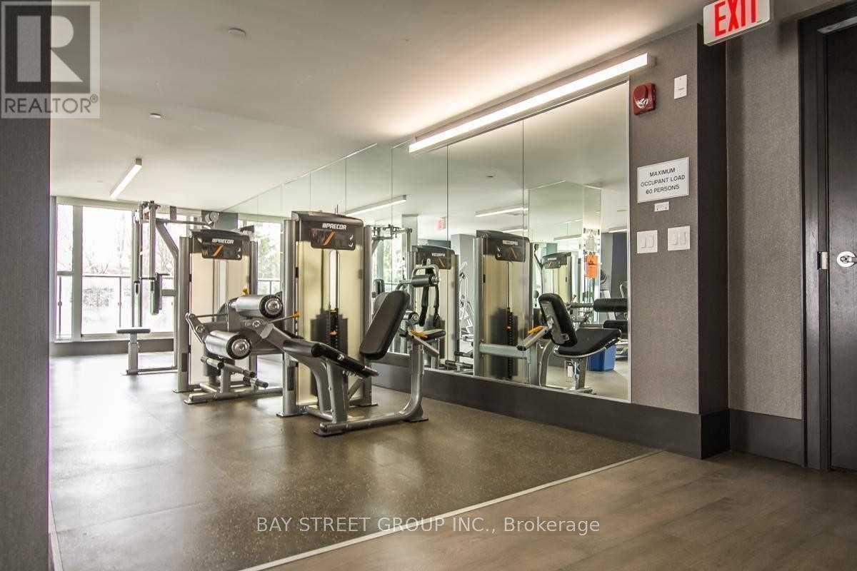 A gym with a mirrored wall and a sign that says exit.