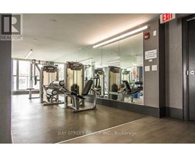 A gym with a mirrored wall and a sign that says exit.