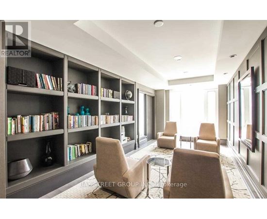 A living room with a bookshelf filled with books and a coffee table in the center.