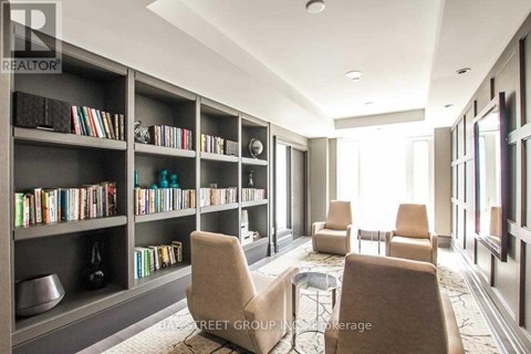 A living room with a bookshelf filled with books and a coffee table in the center.