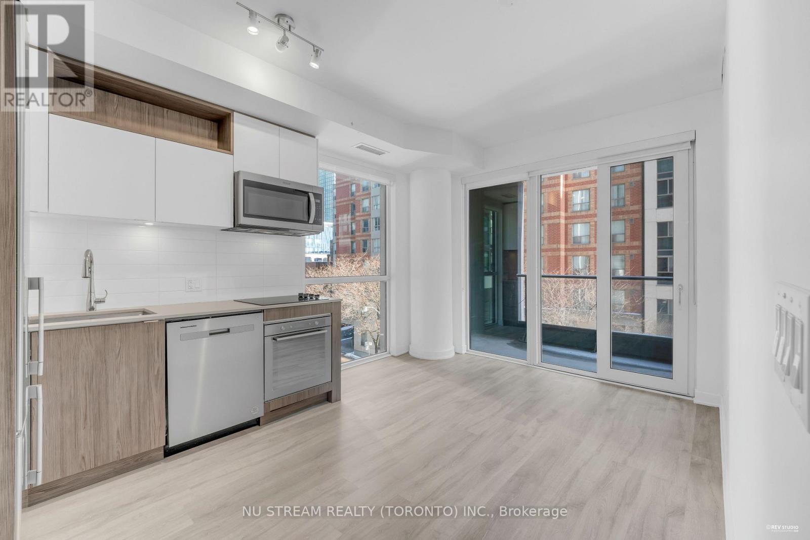 A modern kitchen with wooden cabinets and stainless steel appliances.