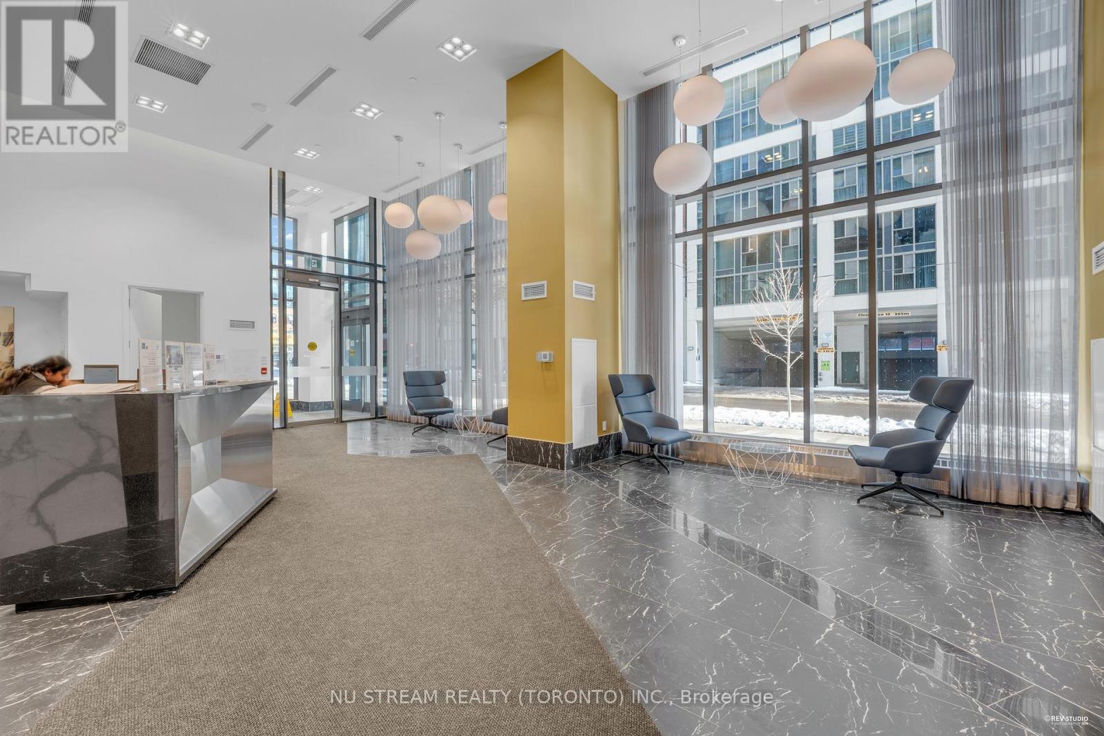 A reception area with a marble floor and a yellow door.