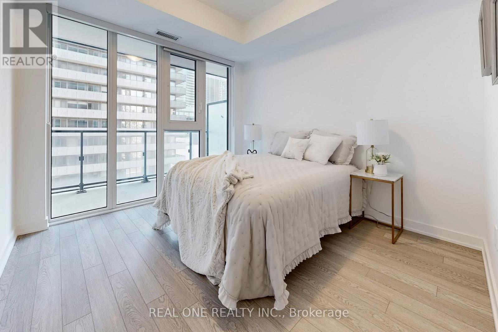 A bedroom with a large bed and a sliding glass door.