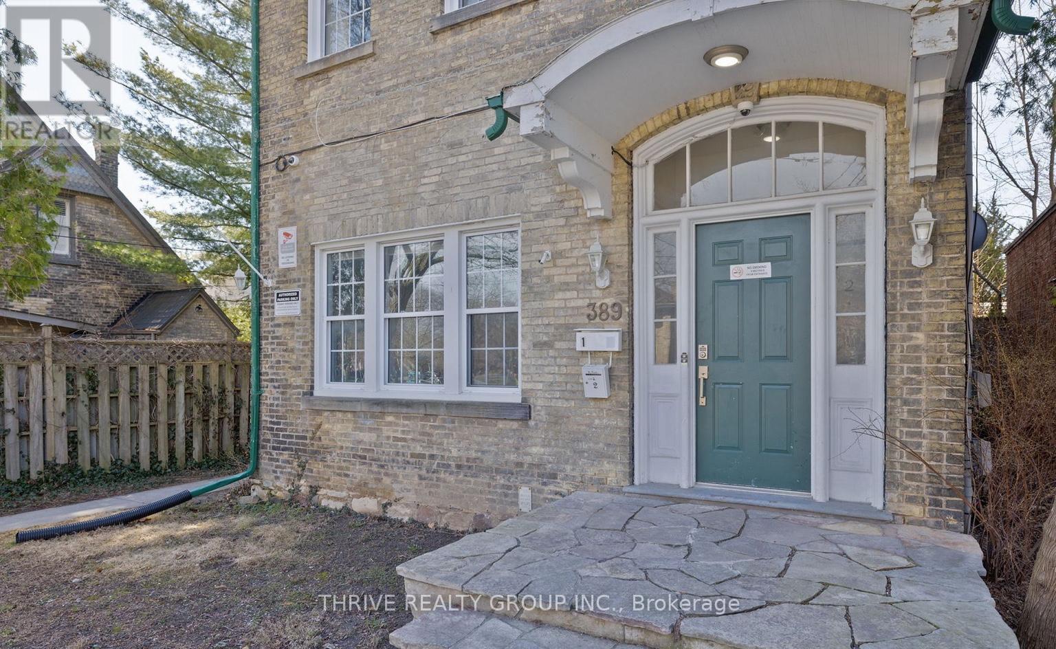 A house with a green door and a stone pathway leading to it.