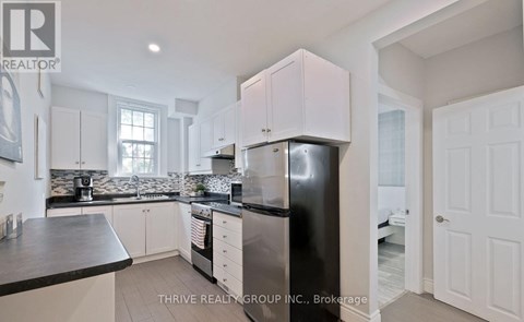 A kitchen with white cabinets and a black countertop.