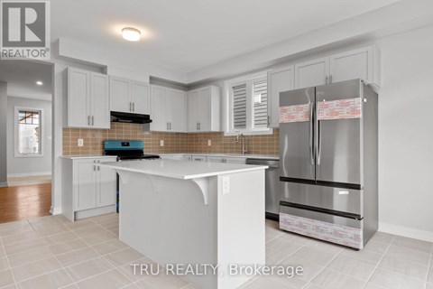 A kitchen with white cabinets and a stainless steel refrigerator.
