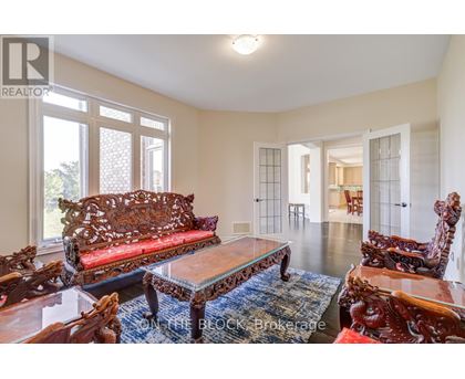 A living room with a red sofa and wooden chairs.