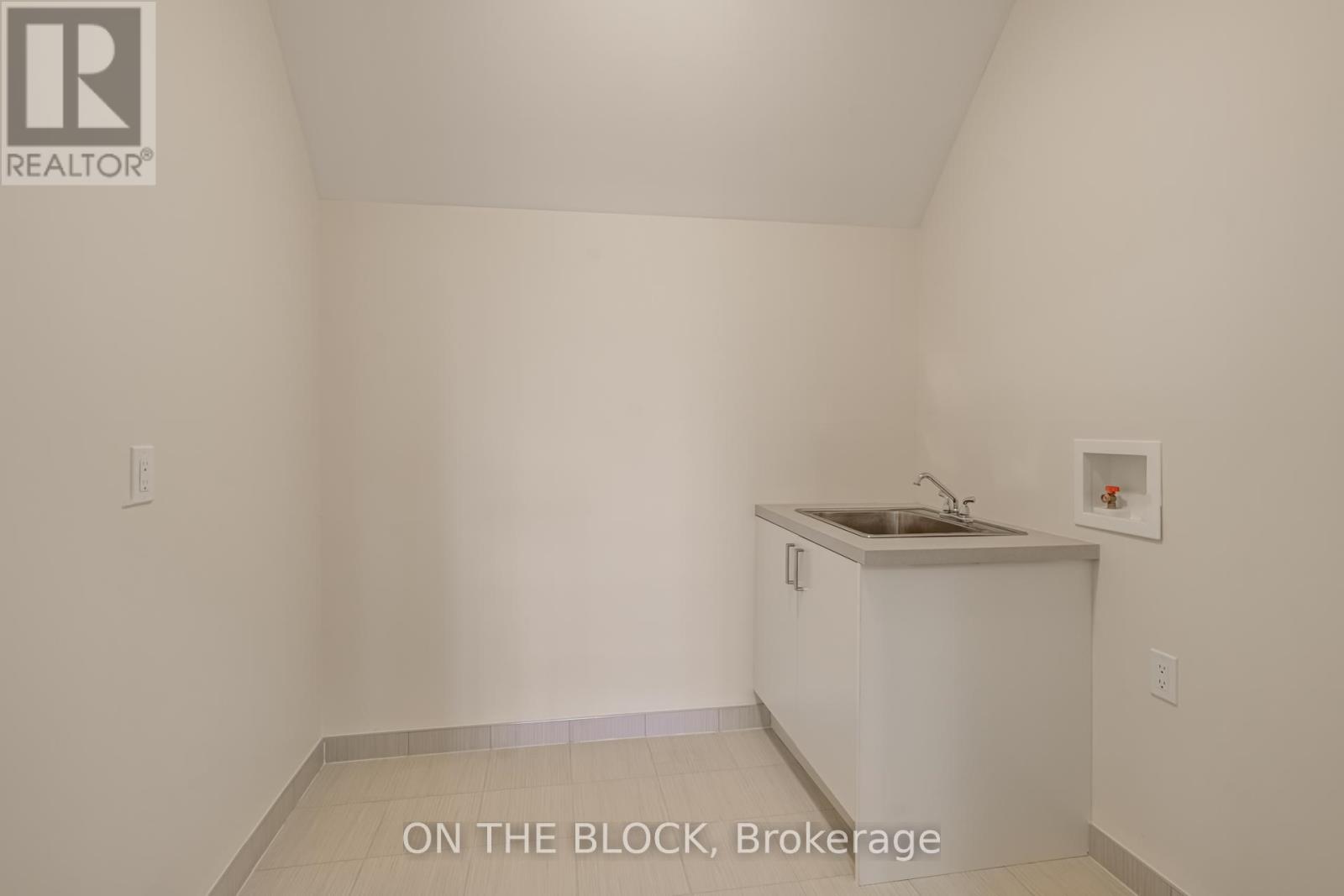 A small white kitchen with a sink and a cabinet.