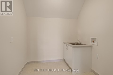A small white kitchen with a sink and a cabinet.