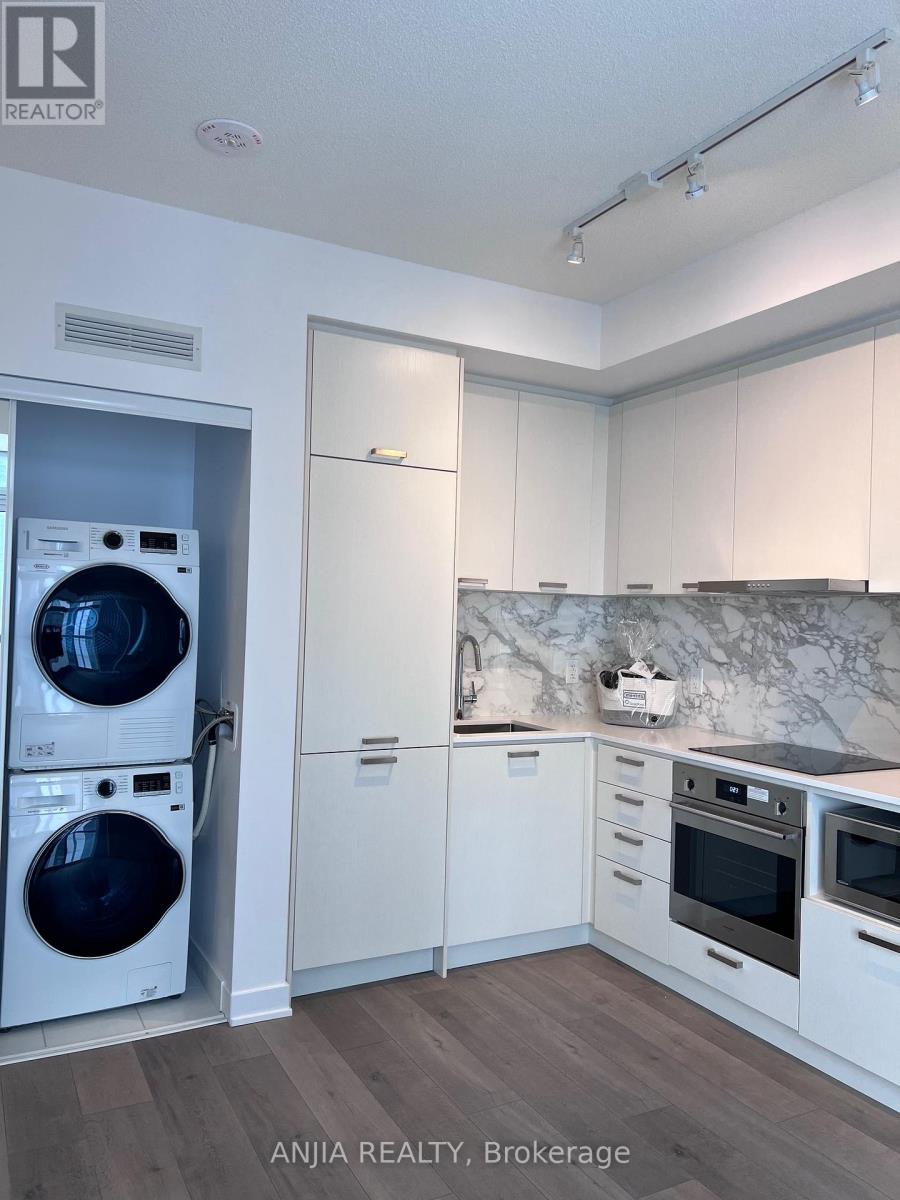 A modern kitchen with a washer and dryer built in.