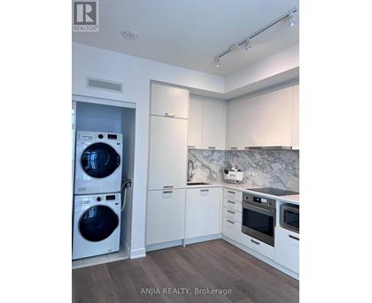 A modern kitchen with a washer and dryer built in.