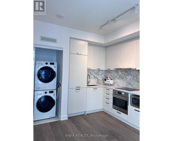A modern kitchen with a washer and dryer built in.