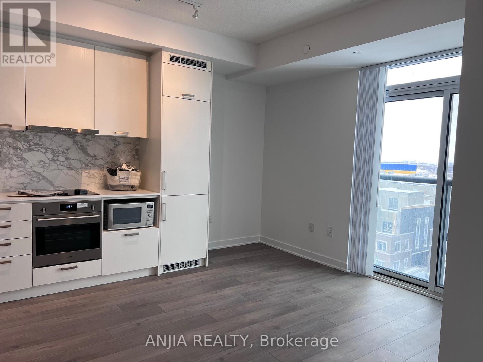 A kitchen with white cabinets and a marble backsplash is shown in the image.