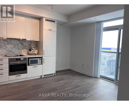 A kitchen with white cabinets and a marble backsplash is shown in the image.