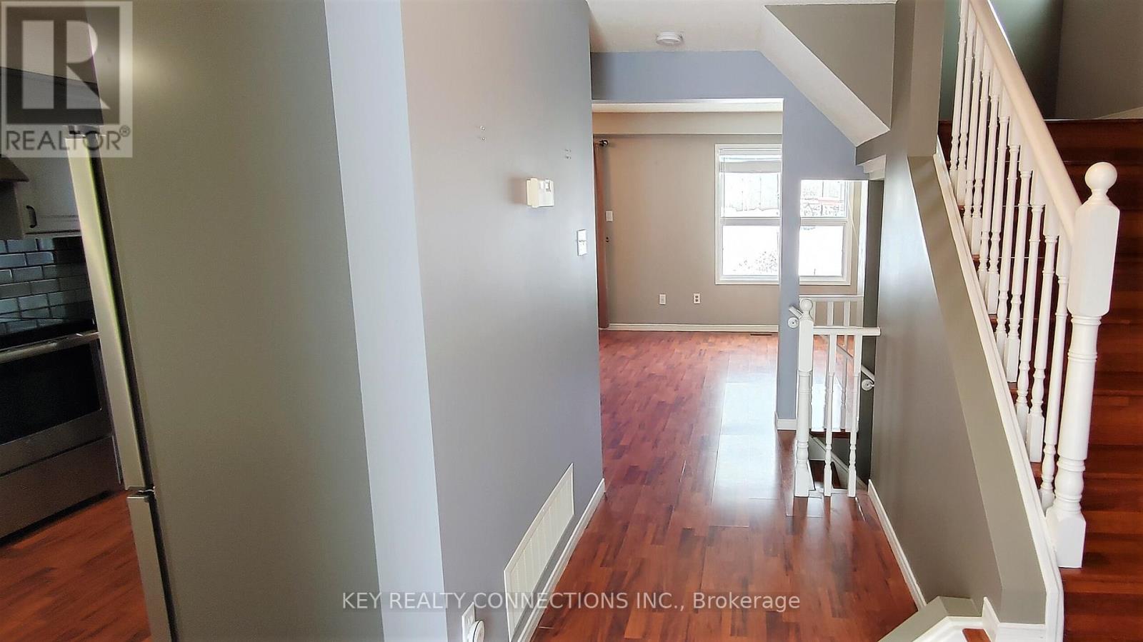 A staircase with a white railing leads to a landing with a door and window.