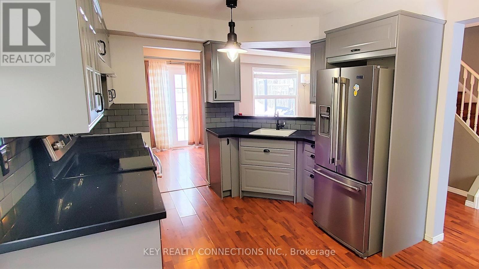 A kitchen with a refrigerator, stove, and cabinets.