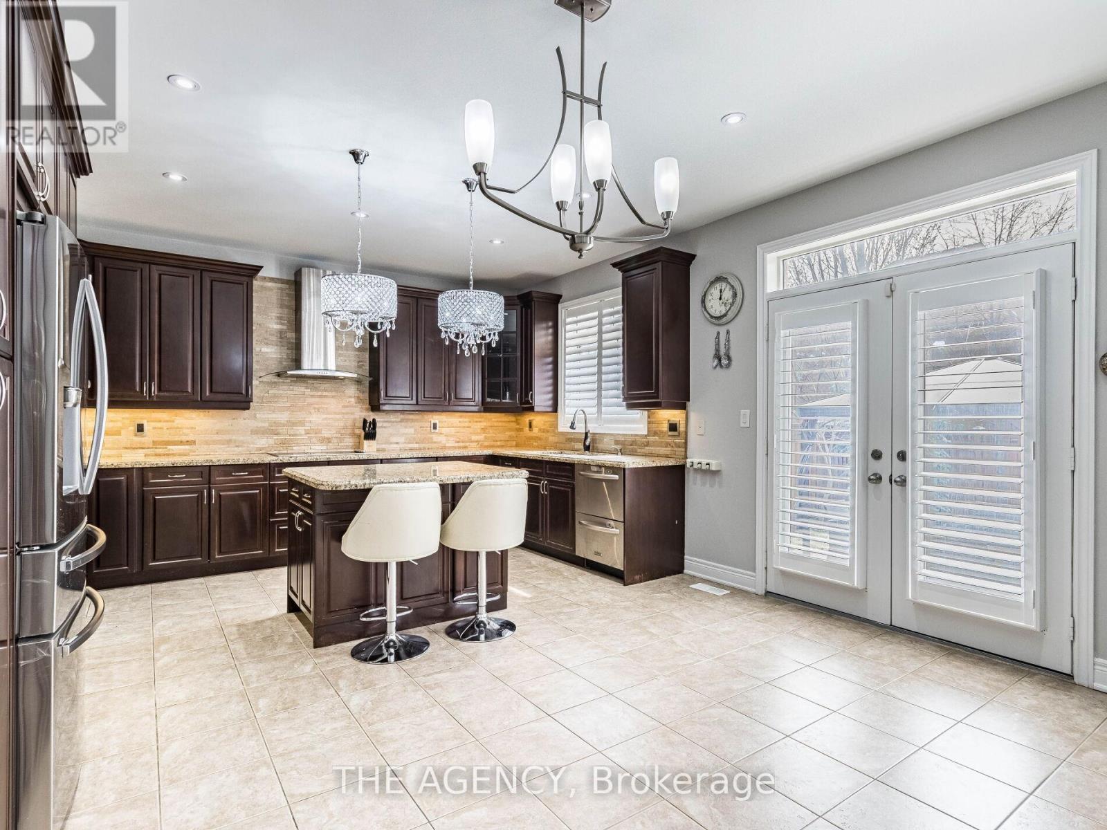 A kitchen with a refrigerator on the left and a bar area in the middle.