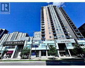 A tall building with a glass facade is the centerpiece of a city street scene.