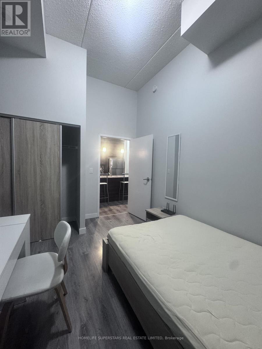 A bedroom with a bed, desk, and chair.
