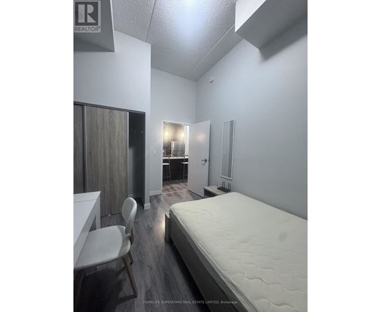 A bedroom with a bed, desk, and chair.