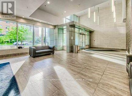 A spacious living room with a couch, a staircase, and a glass wall.
