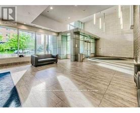 A spacious living room with a couch, a staircase, and a glass wall.