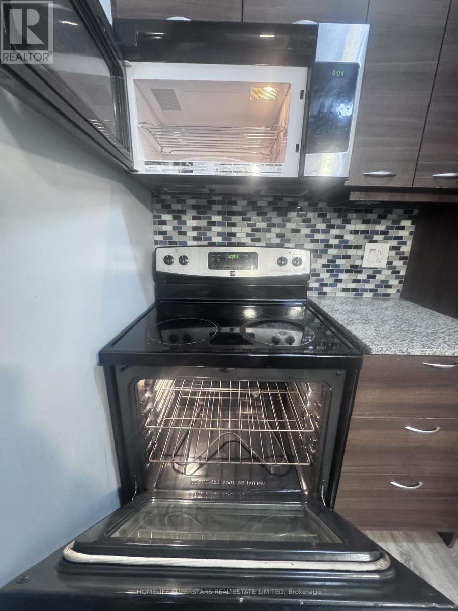 A black oven with the door open is in a kitchen.