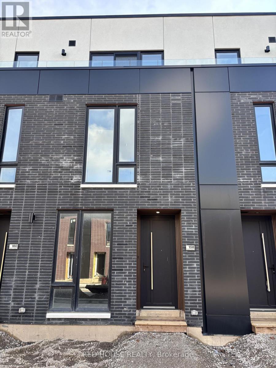 A modern building with a black and grey facade and a large window in the front.