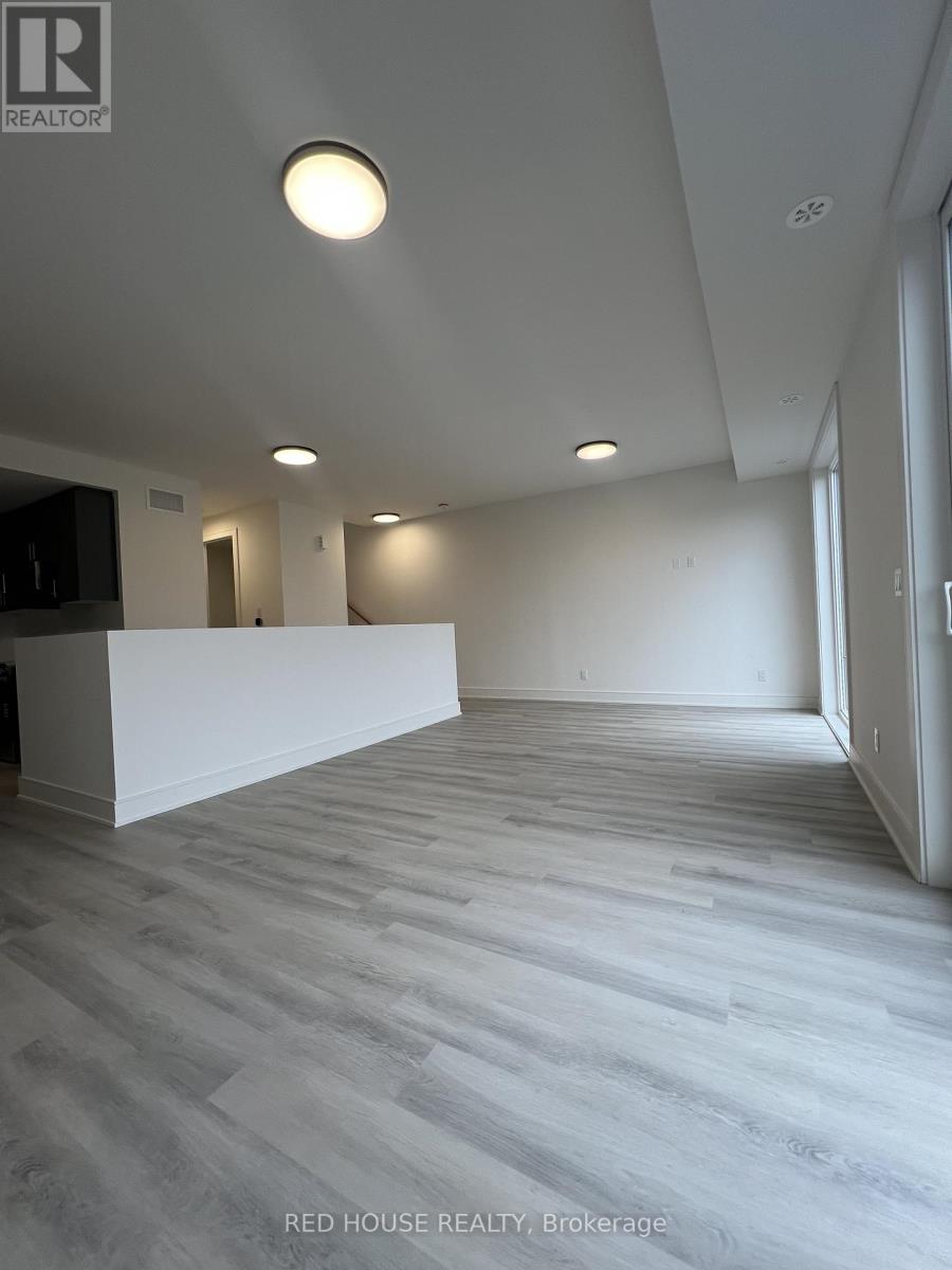 A spacious room with a white reception desk and grey flooring.